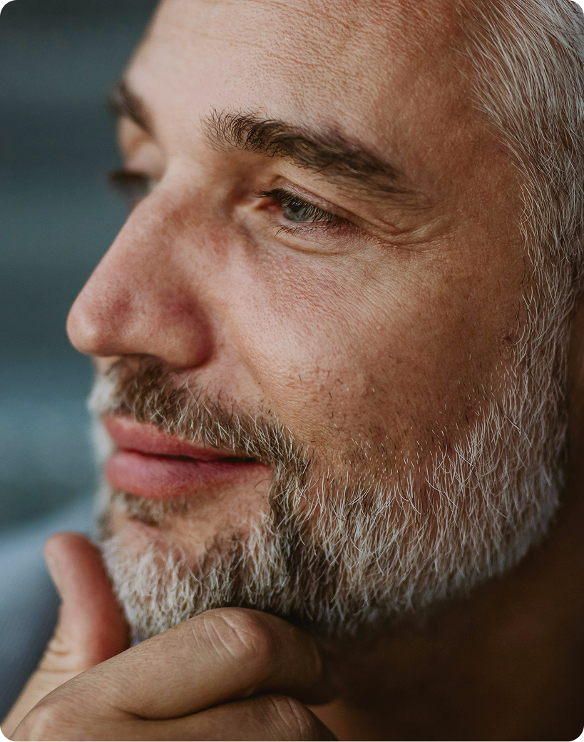 Close-up of a confident older man smiling thoughtfully, representing natural-looking facial rejuvenation with Botox injections at Gameday Men’s Health