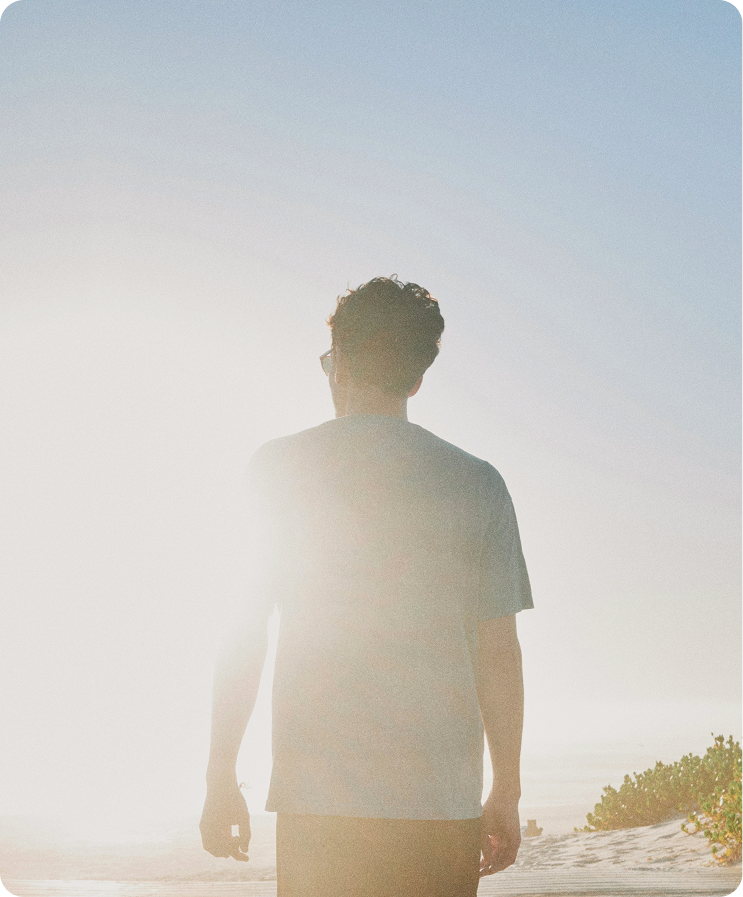 Man walking along the beach at sunrise, reflecting steady energy and lifestyle balance supported by Testosterone Pellets in Toronto
