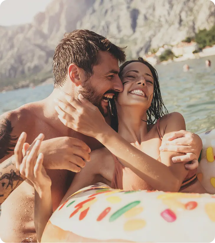 Man and woman smiling and talking while swimming in the sea, reflecting confidence and connection supported by PRP Shot for ED in Toronto