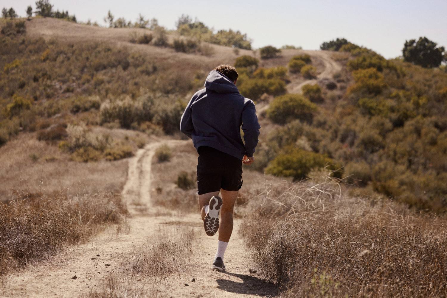 Man running outside on a trail symbolizing how hormone health enables an active lifestyle.