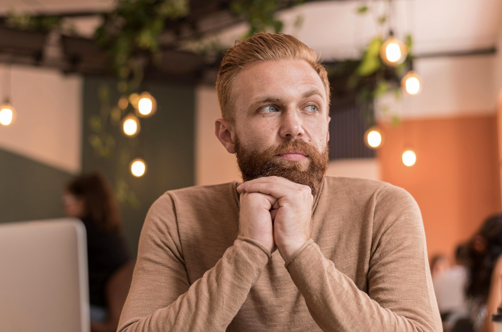 Thoughtful man sitting in a café reflecting, symbolizing considerations and potential side effects associated with phentermine treatment