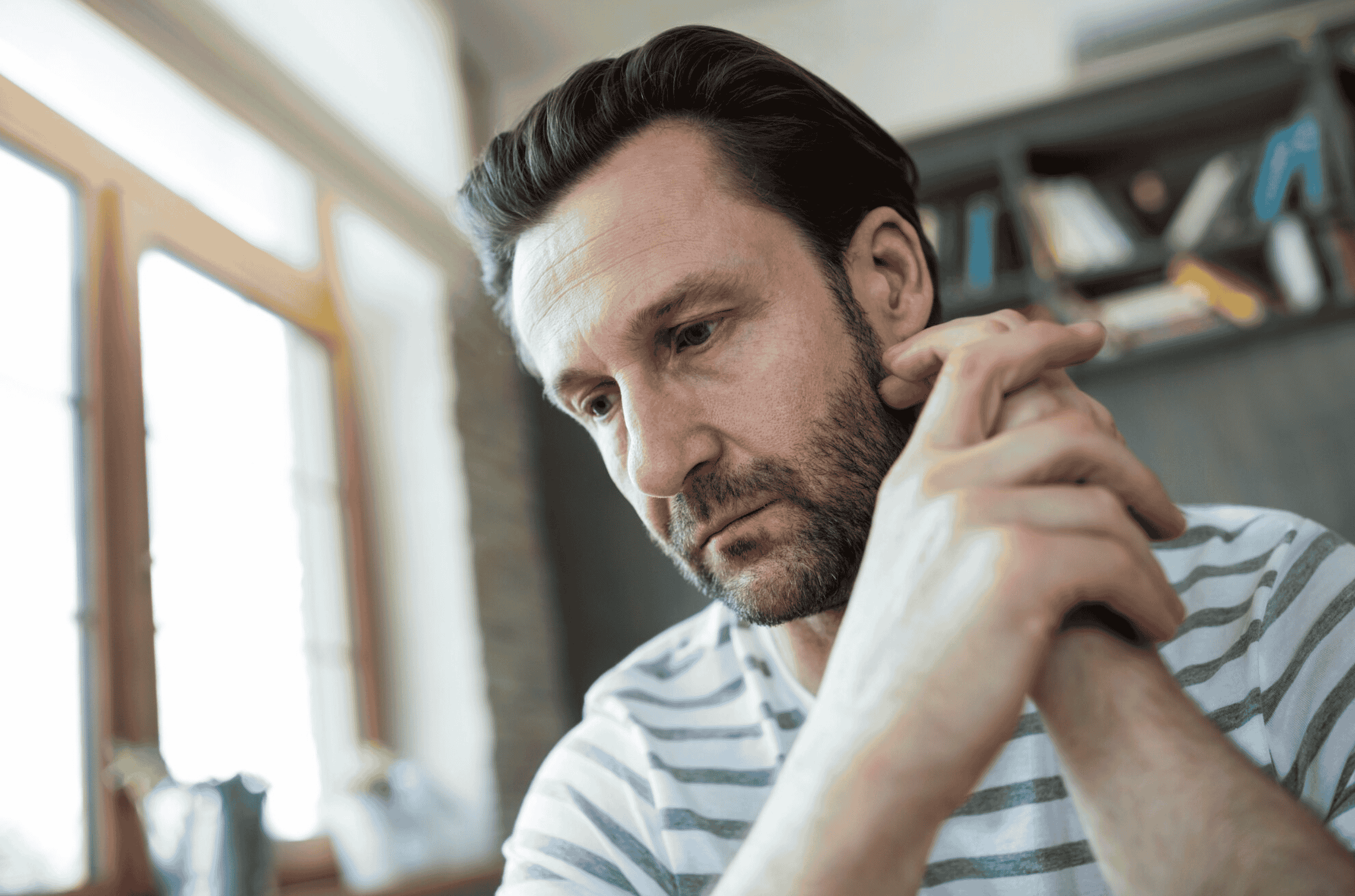 Thoughtful man sitting and reflecting, representing concerns and potential side effects associated with minoxidil use
