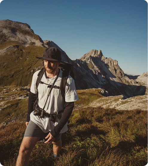 Man hiking through mountainous terrain, reflecting endurance and metabolic support associated with MOTS-C Peptide Injections in {{location_name}} at Gameday Men’s Health {{city}}