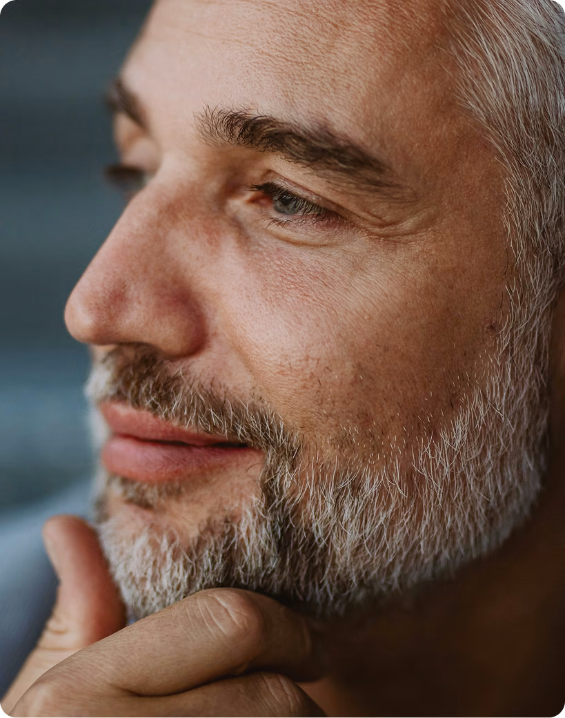 Close-up of a confident older man smiling thoughtfully, representing natural-looking facial rejuvenation with Botox injections at Gameday Men’s Health