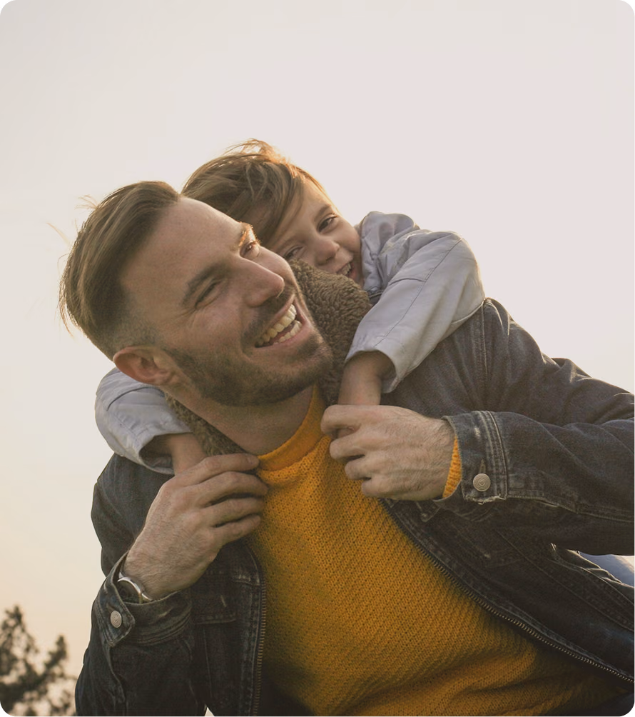 Happy man playing outdoors with a child, representing energy, vitality, and quality-of-life support associated with Vitamin B12 injections in Elmhurst, Illinois.