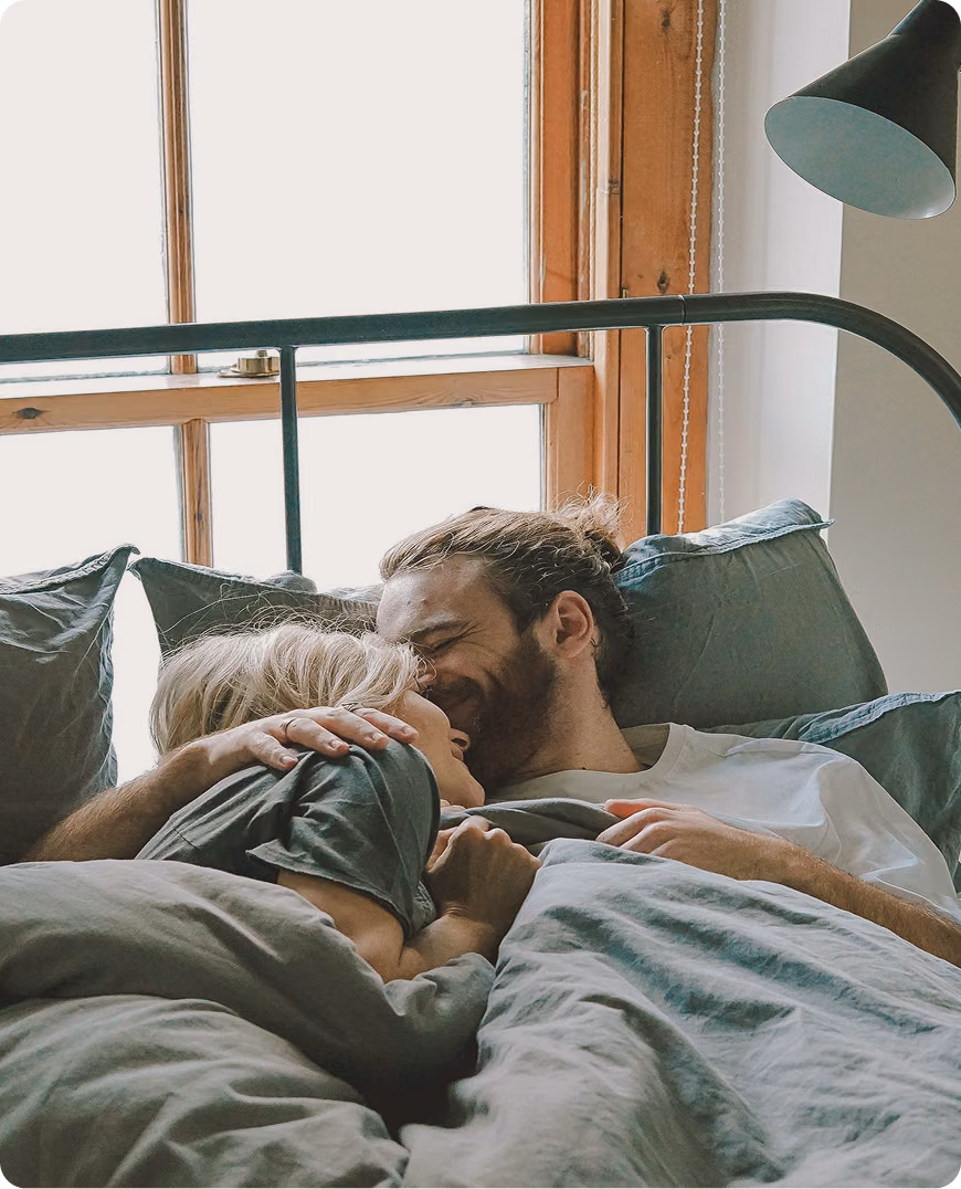 Man and woman lying in bed smiling, reflecting comfort and confidence supported by Viagra and Cialis in Missouri at Gameday Men’s Health