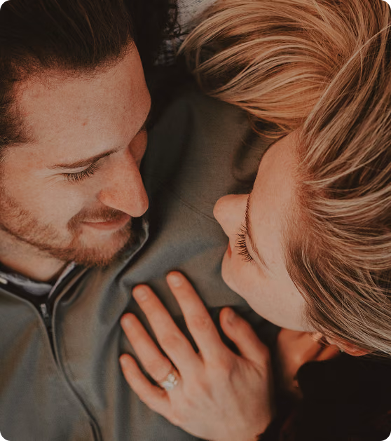 Smiling couple relaxing in bed in Edwardsville, IL, reflecting improved intimacy after shockwave therapy at Gameday Men’s Health.