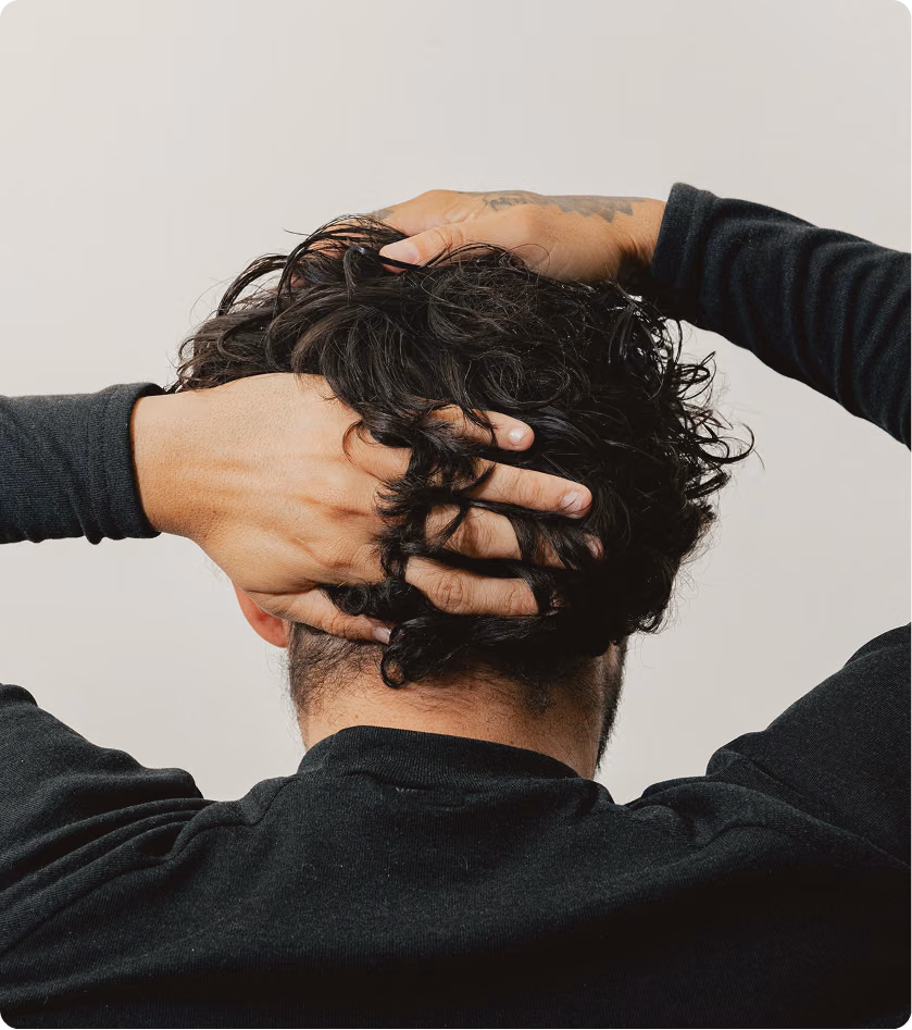 A man checking hair appearance, symbolizing proactive hair health and restoration care available at Gameday Men’s Health in Leesburg, FL.