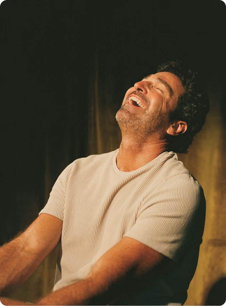 Man sitting and smiling in a relaxed setting, reflecting improved mood and well-being supported by Oral TRT Kyzatrex in Missouri