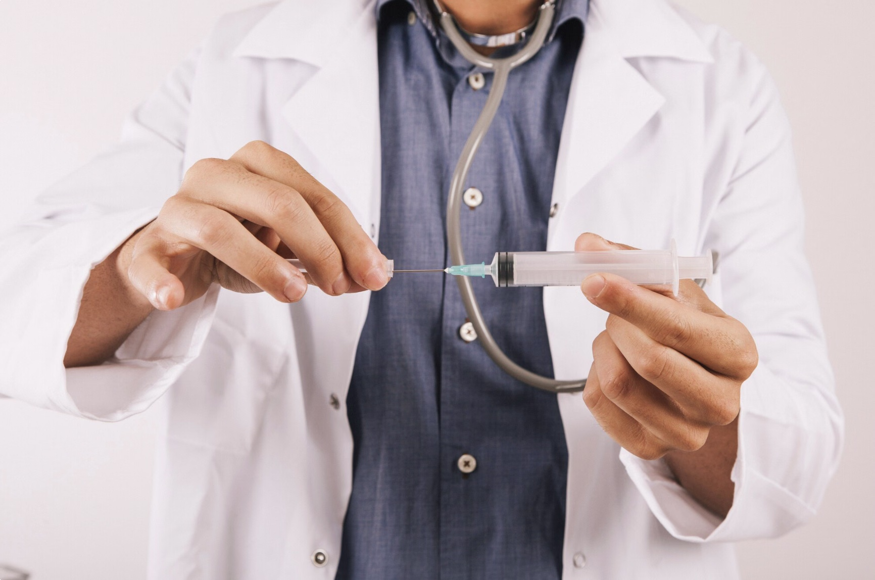 Doctor holding a syringe during medical consultation, representing clinical administration and explanation of how semaglutide treatment works