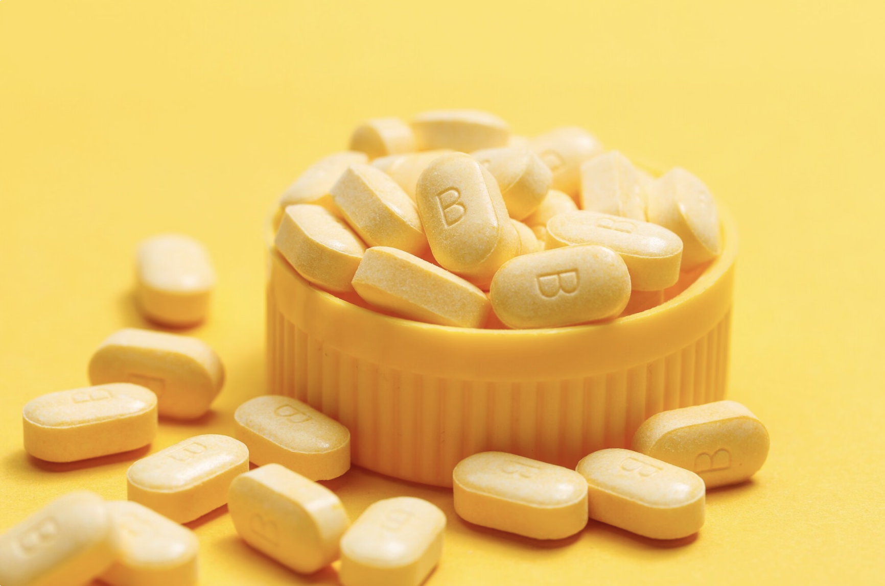Vitamin B12 supplements and capsules with letter B labeling, illustrating dosage and supplementation considerations for maintaining healthy B12 levels