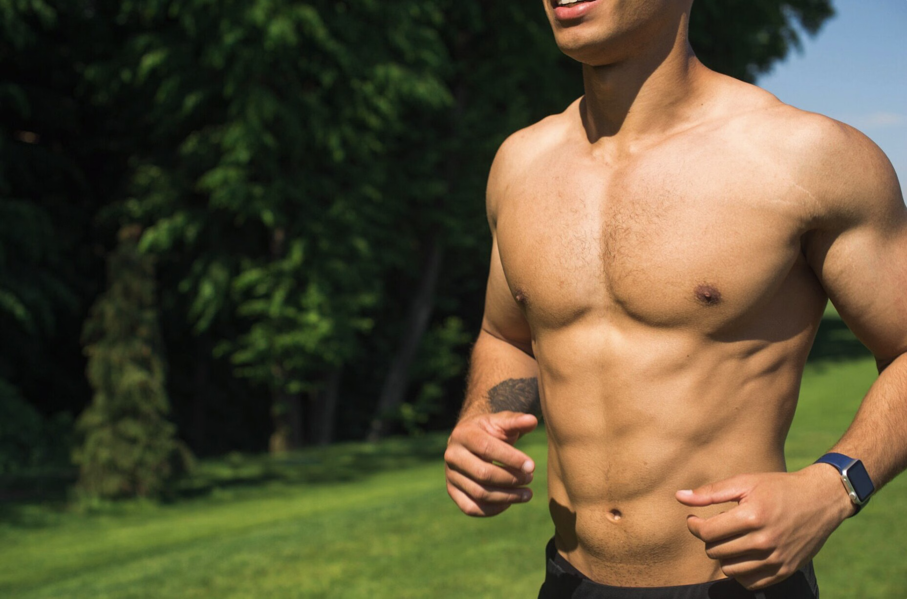 Fit, healthy man running through a park, representing lifestyle habits like exercise and movement that can support natural testosterone levels.