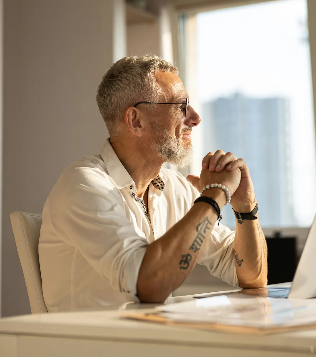 Man sitting at a desk by a window.