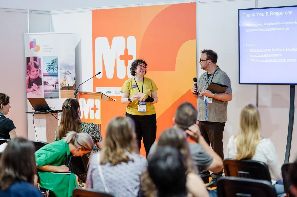 Theatre 2 at the M+H show - orange branding covers the walls