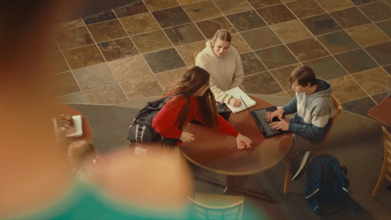 Man looks down at people sitting around table