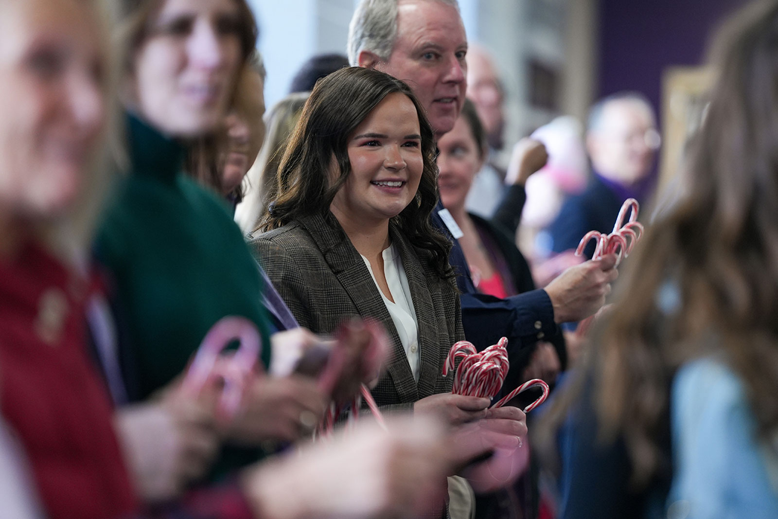 Event photograph of professors and staff giving candy canes to sudents