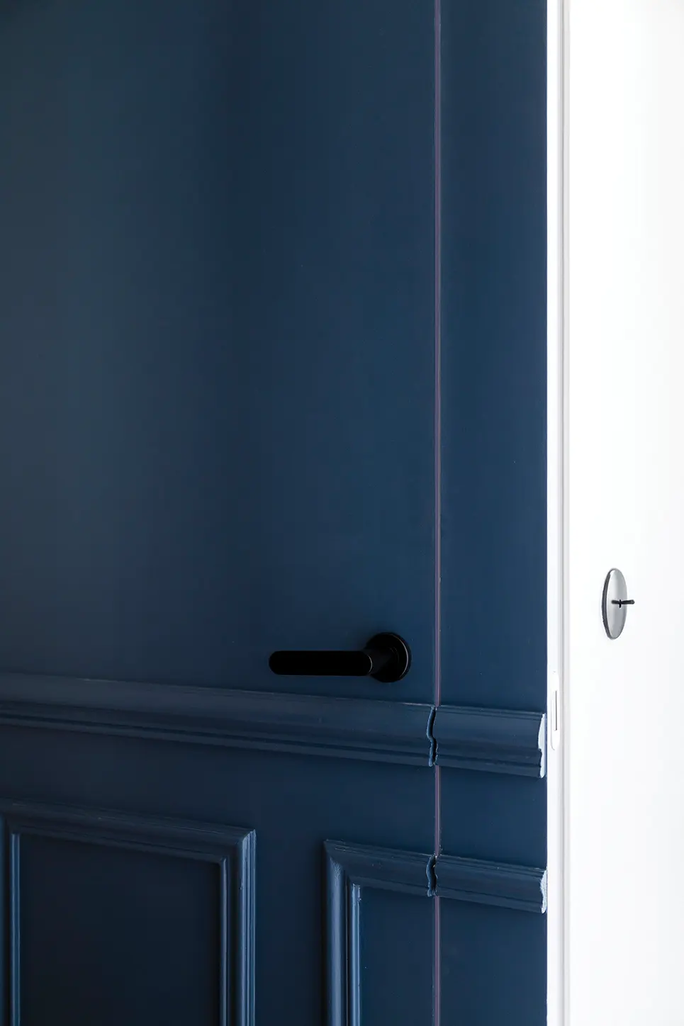 détail d'une porte sous tenture dans un appartement haussmanien