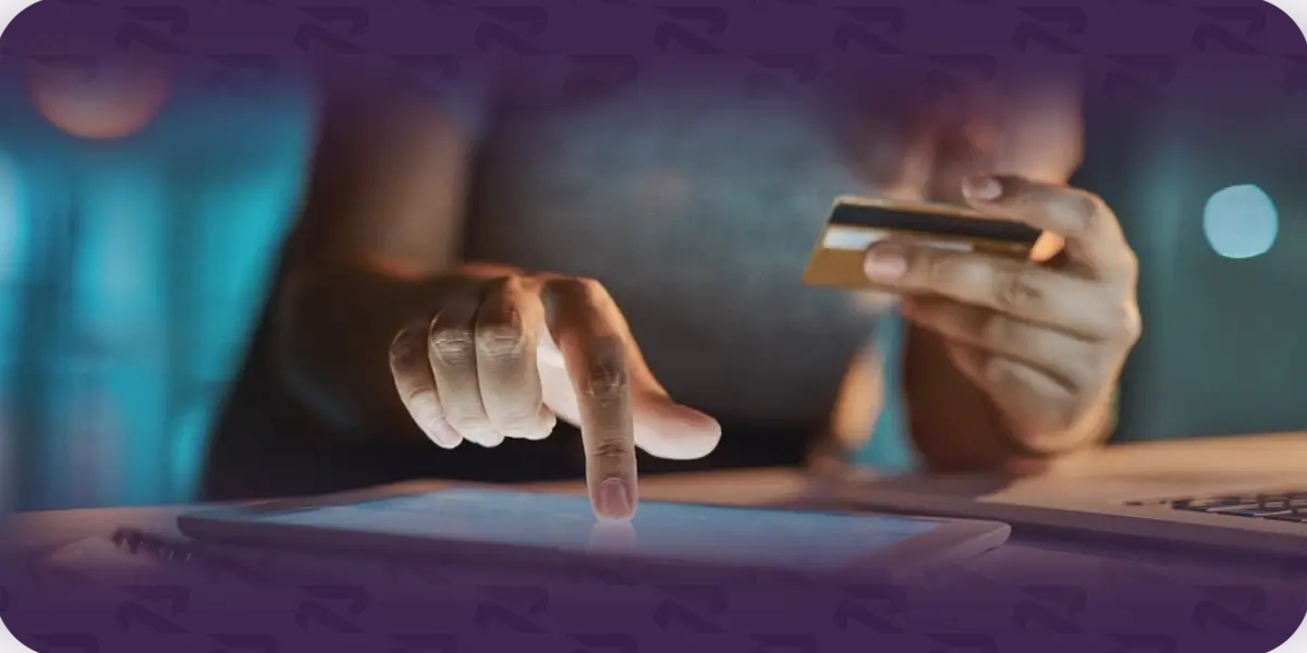 Person booking car shipping online using a tablet and credit card.
