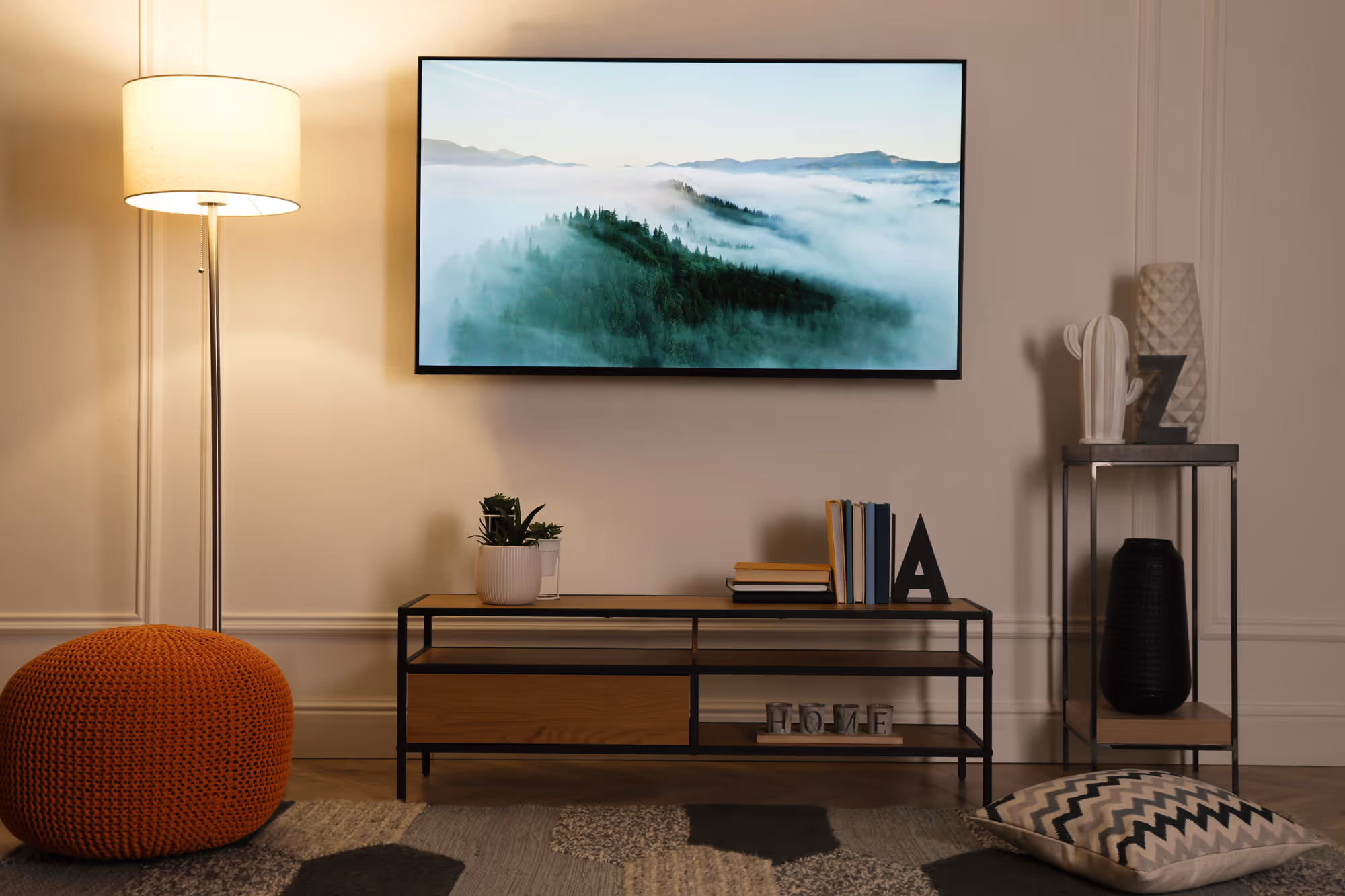 A TV in a living room with a beautiful landscape on the screen.