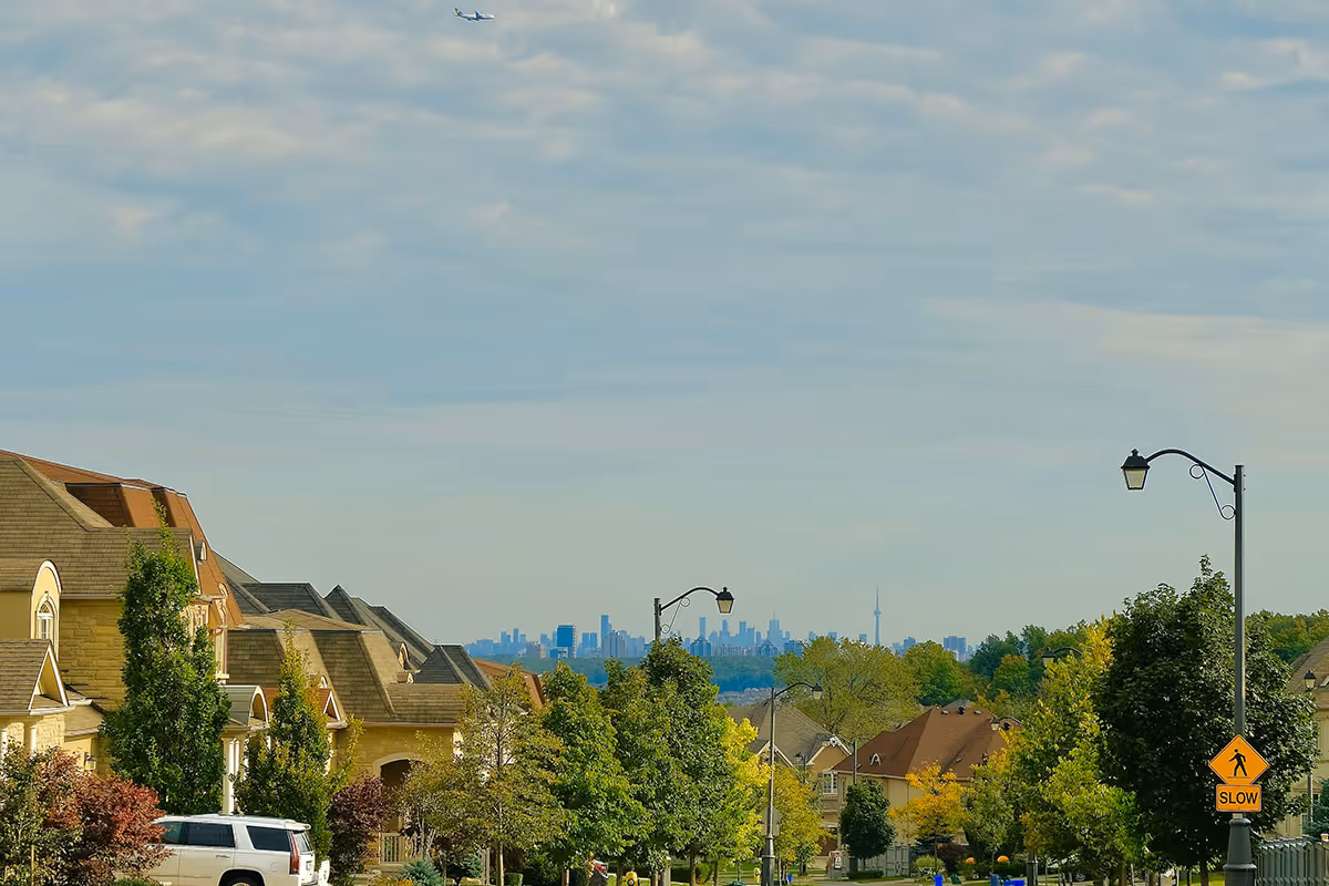 A residential street in Vaughan, ON, with the Toronto skyline in the distance.