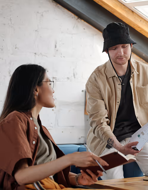 Two coworkers reviewing documents together in a modern office with natural light
