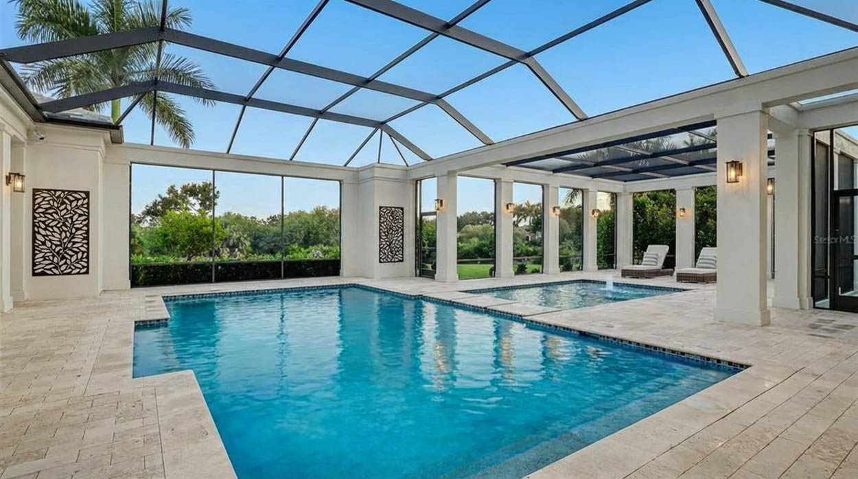Luxury pool screen enclosure with covered patio built by professional pool enclosure contractors in North and South Florida.