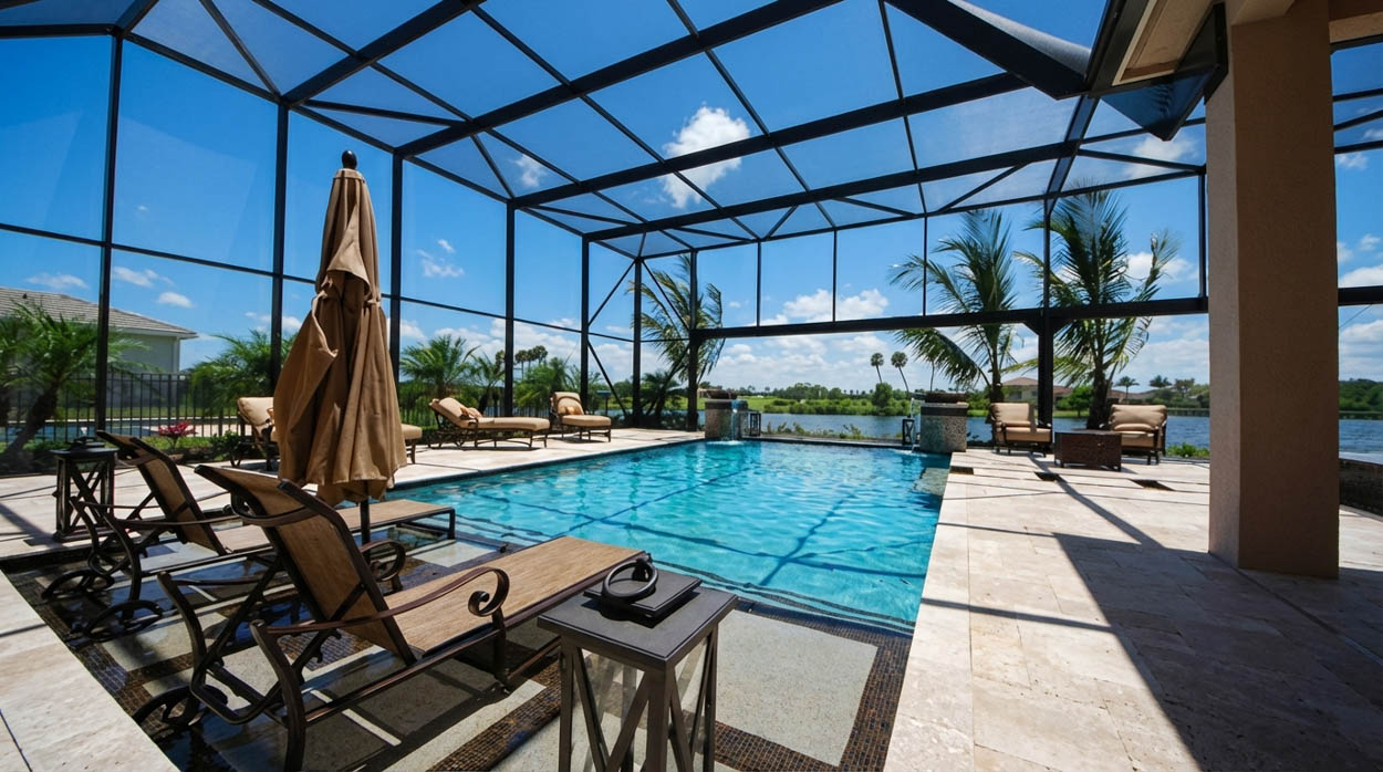 Spacious pool screen enclosure with lounge seating built by trusted pool enclosure installers in South Florida.