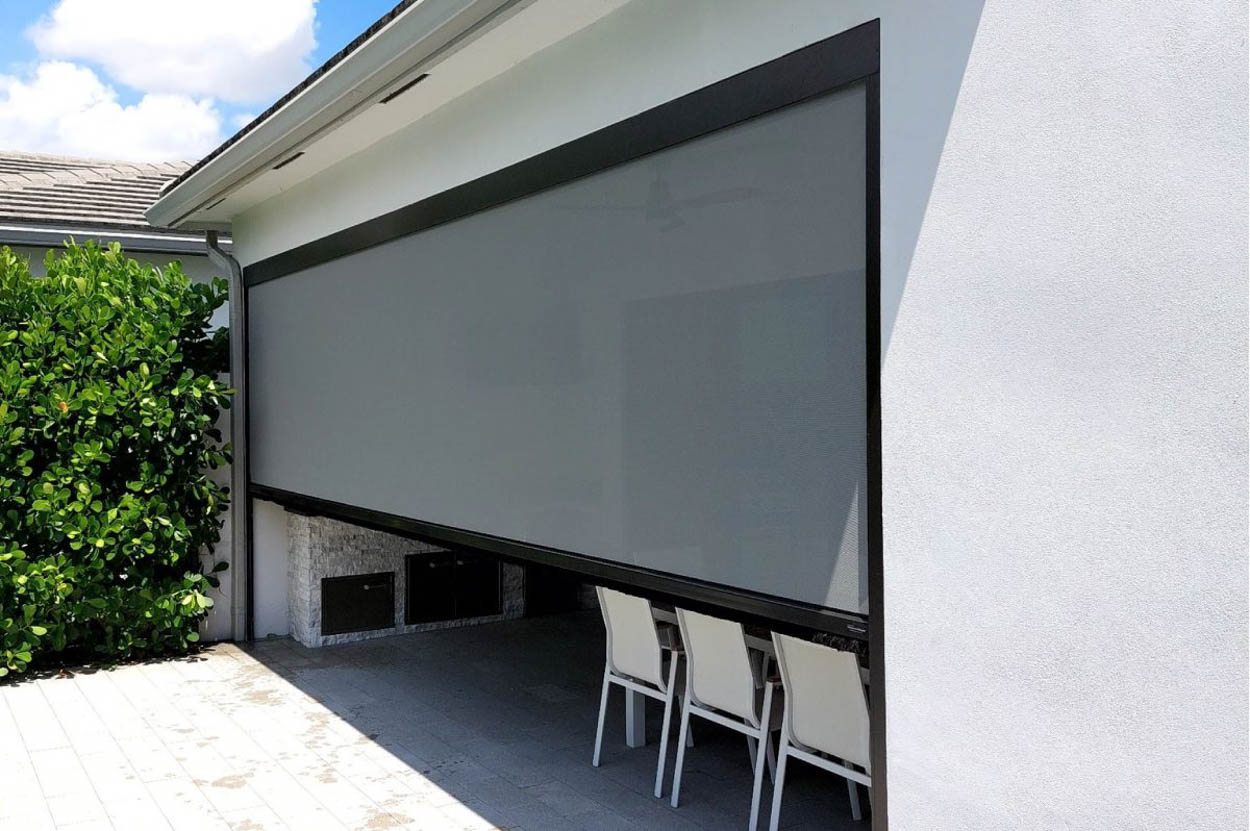 Exterior motorized retractable screen system designed for sun control, privacy, and weather protection on patios and outdoor kitchens in Florida homes.