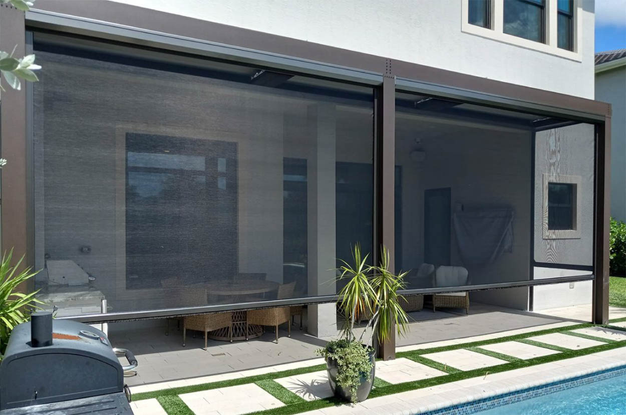 Custom motorized retractable screens installed on a backyard patio, creating a comfortable outdoor environment for families in South Florida.