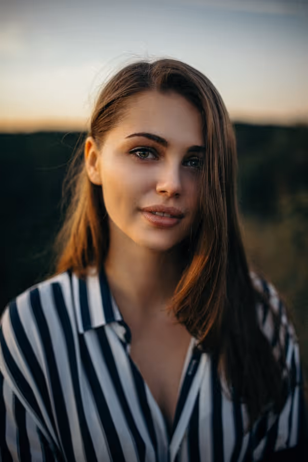 smiling woman wearing white and black pinstriped collared top
