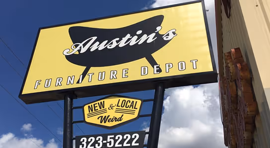 Austin's Furniture Depot sign with a mid-century modern chair silhouette and a smaller sign reading New & Local Weird.