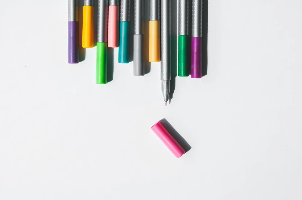 Assorted color pens on a white background