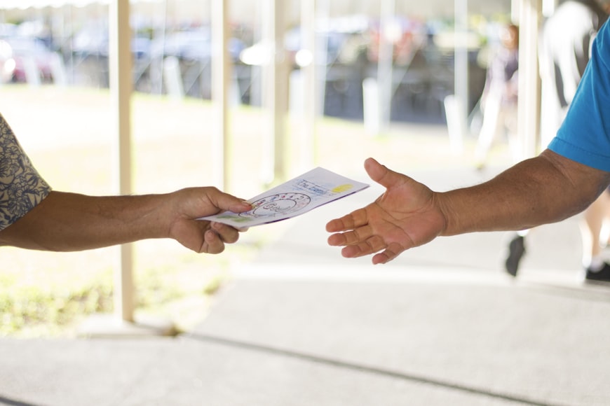A Faceless Person Receiving a Brochure with a White Background and Colorful Graphic Design