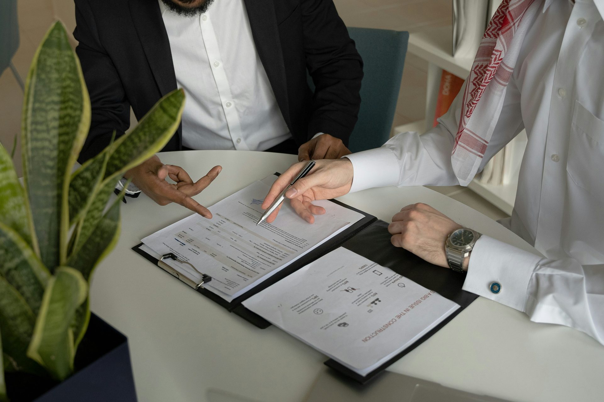 Close-up of a contract being signed at an office desk