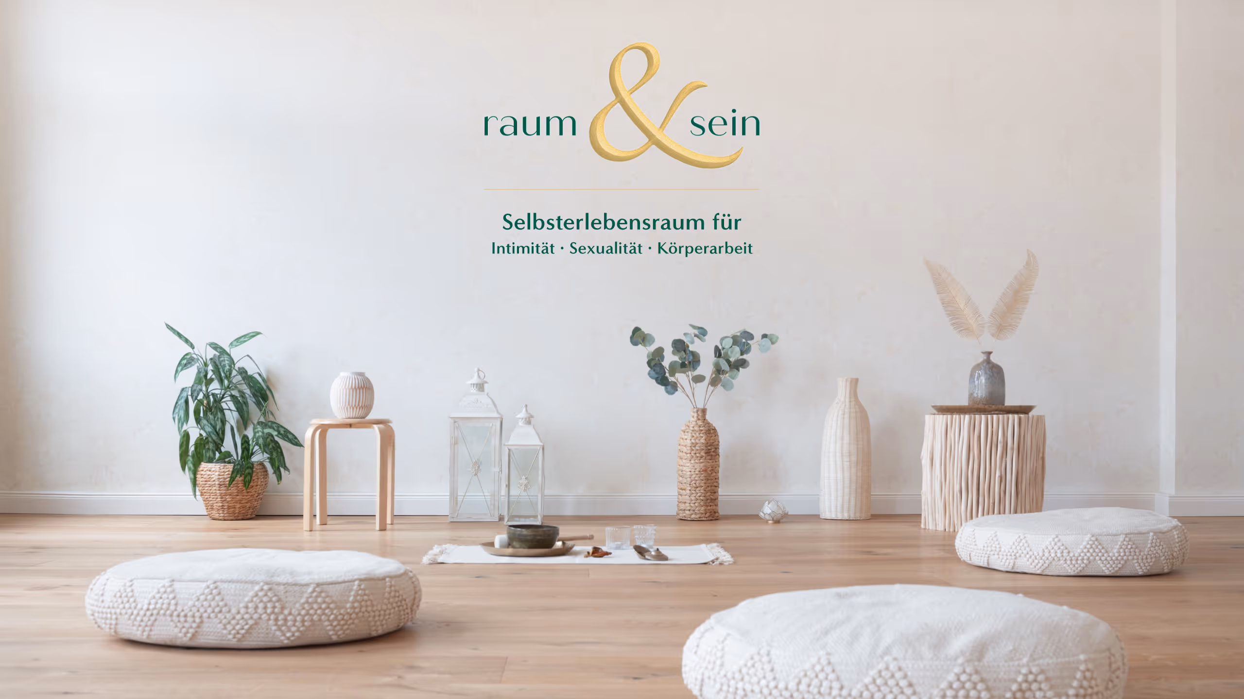 Heller, minimalistischer Raum mit drei runden Sitzkissen auf Holzboden, verschiedenen Dekorationen und Pflanzen vor weißer Wand mit Schriftzug Raum & Sein.