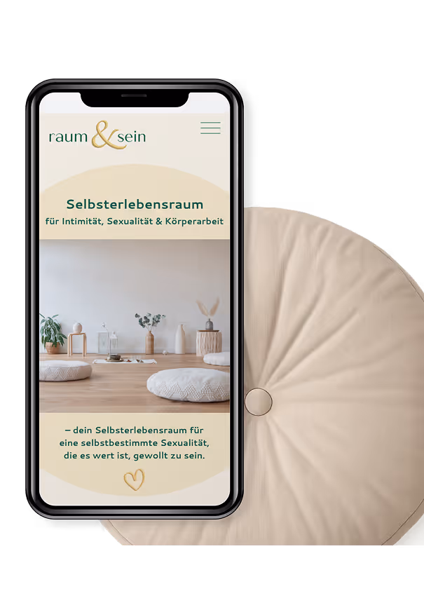 Smartphone mit Website von raum & sein, zeigt ein ruhiges Interieur mit Kissen, Pflanzen und Kerzen, Text über Selbsterlebensraum für Intimität, Sexualität und Körperarbeit.
