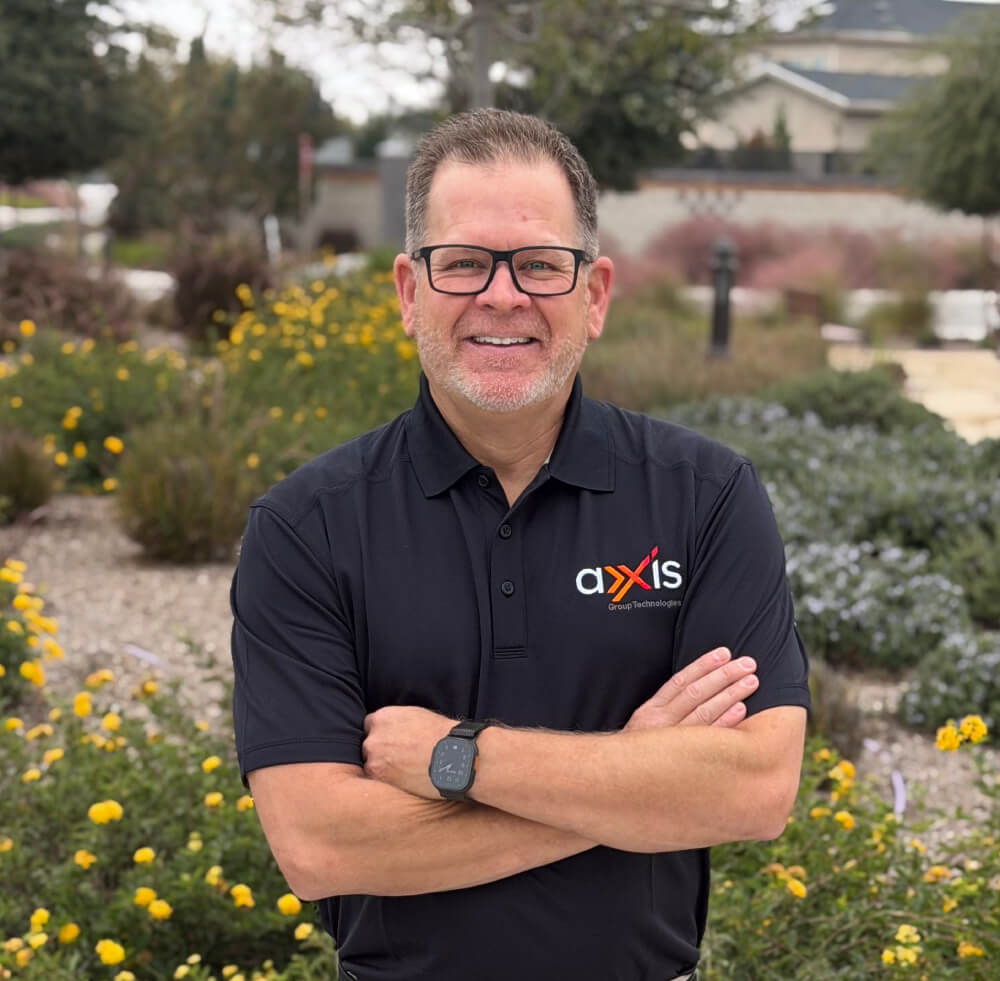 AXXIS Group Technologies IT professional smiling with arms crossed outdoors in Bakersfield CA
