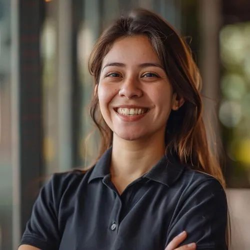 Smiling AXXIS Group IT support technician in uniform standing confidently with arms crossed in office