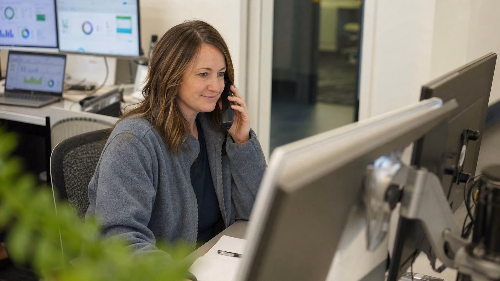 Businesswoman on phone call, focused on computer screen 60 chars