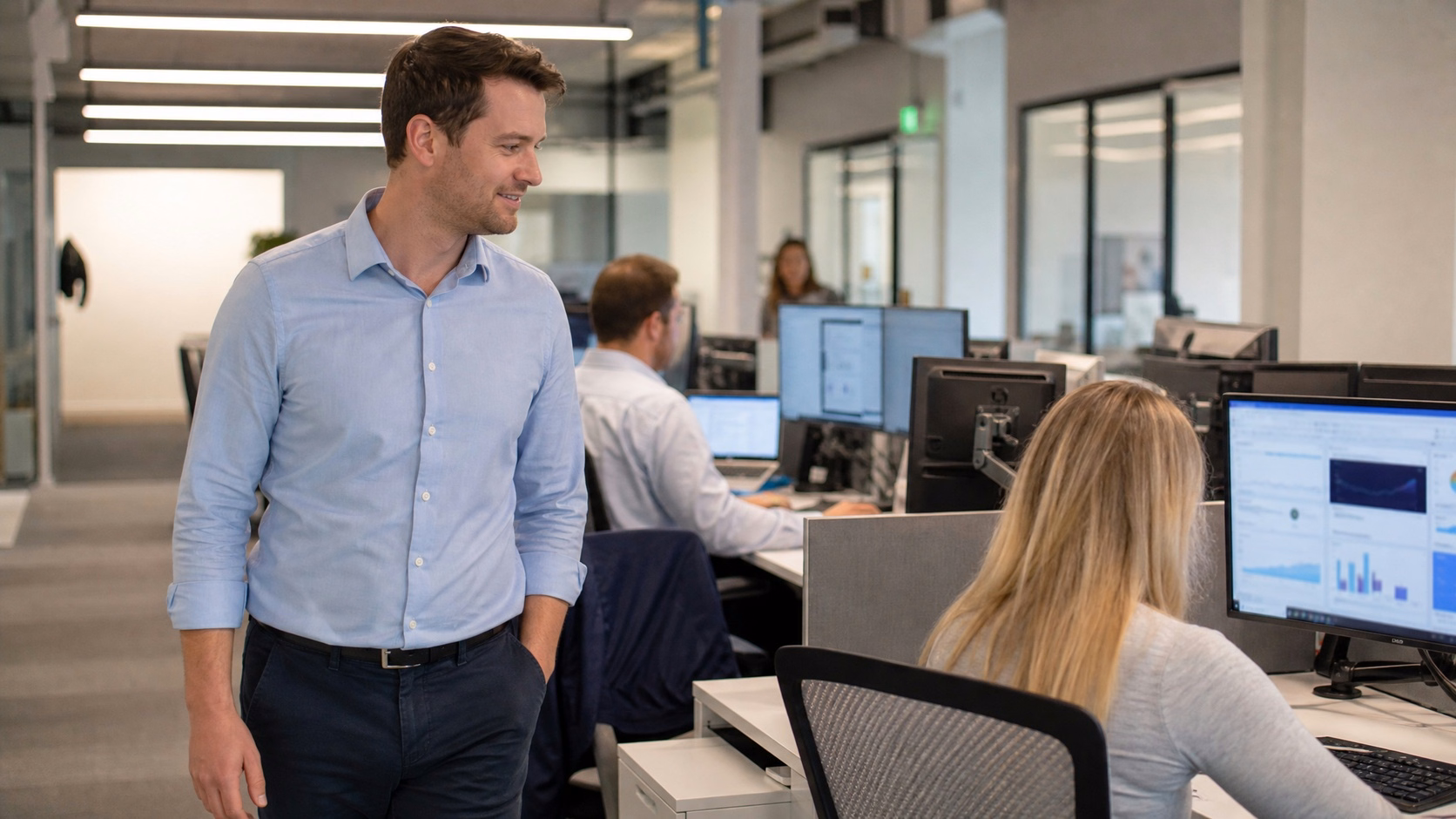 Man in blue shirt walks past office computer screen 59 chars