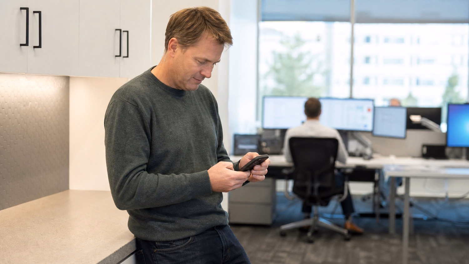 Man reviews compliance docs on phone at kitchen counter