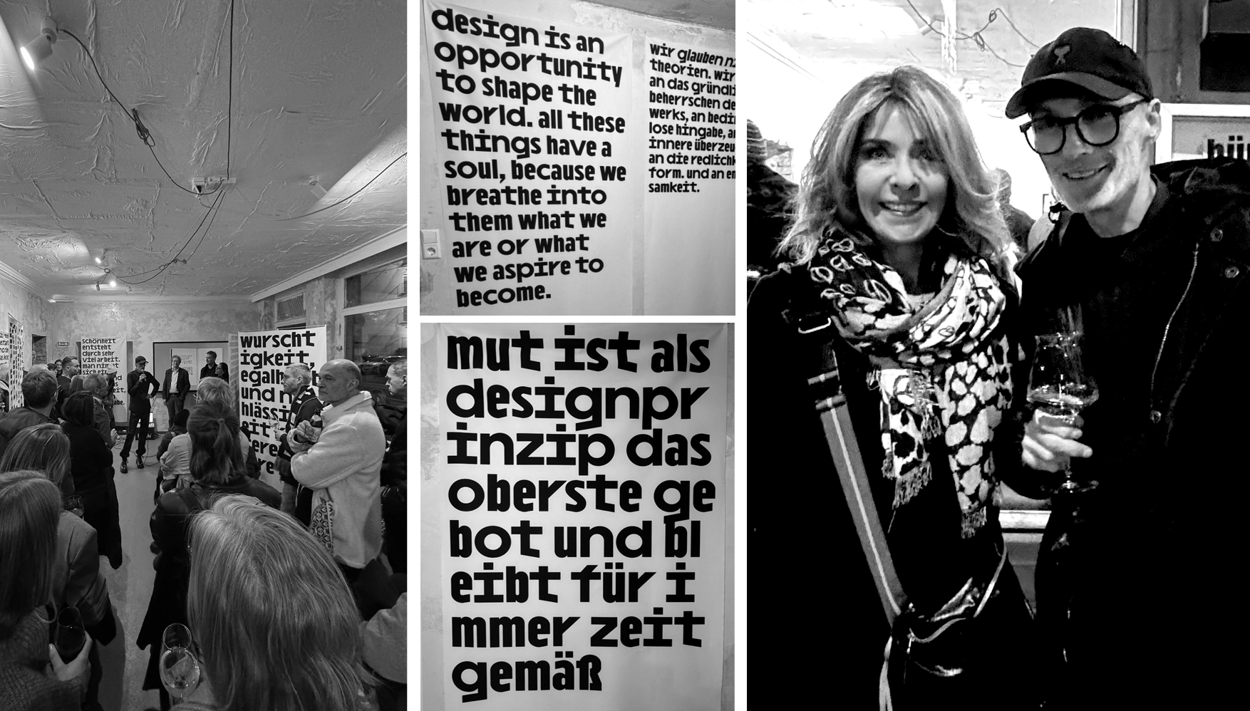 Black and white photo of a group of people attending a gallery or presentation with large posters featuring bold text about design, alongside a photo of two people smiling, one holding a glass of wine.