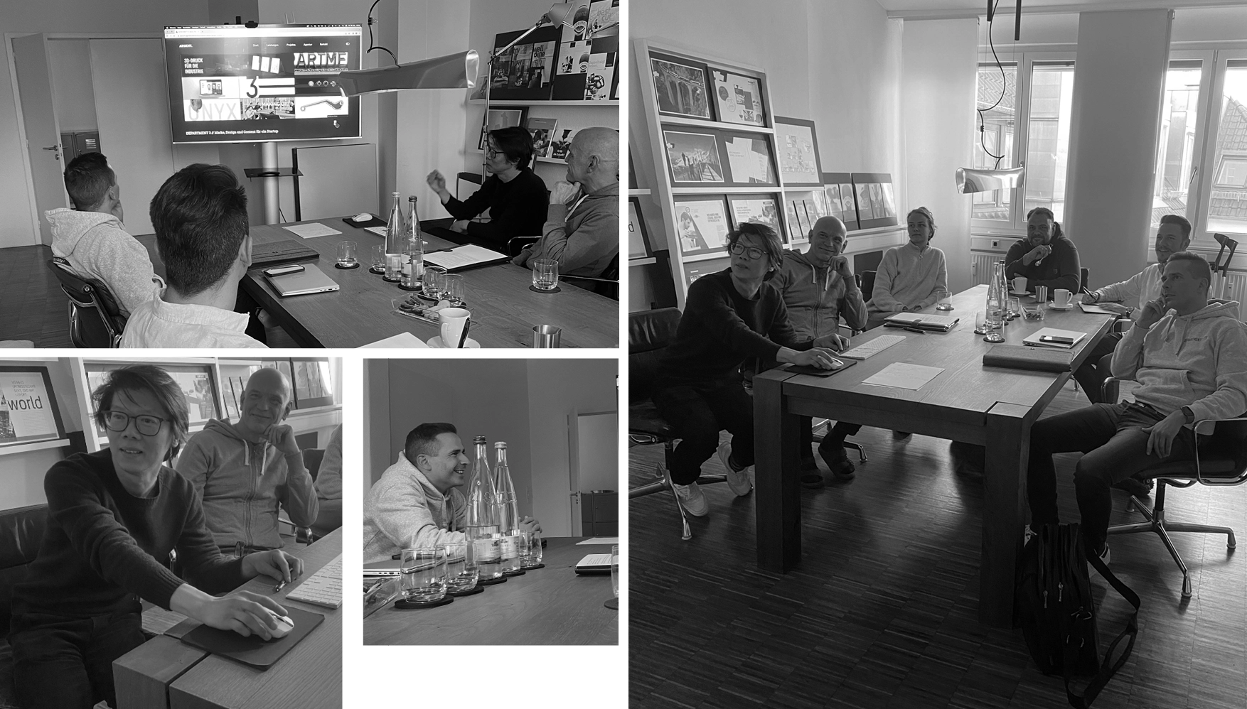 Group of people in a modern office having a meeting around a wooden table, looking at a screen and discussing.