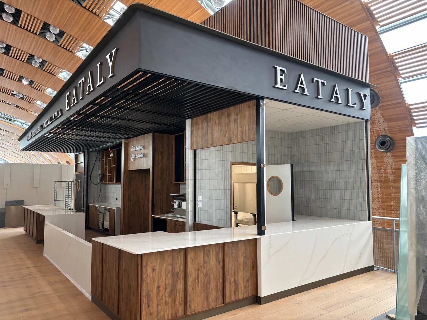Agencement EATALY à Paris–Charles-de-Gaulle : structure métallique, enseigne et comptoir, photographiés avant l’ouverture.
