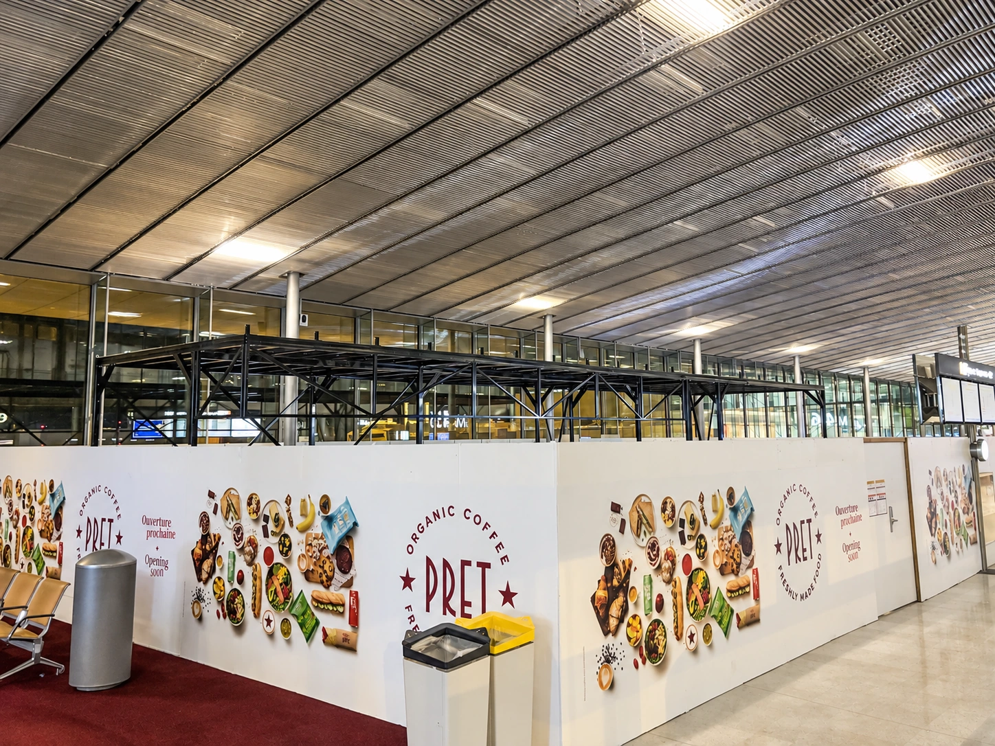 Deuxième mezzanine PAM visible au-dessus des palissades du chantier dans le hall