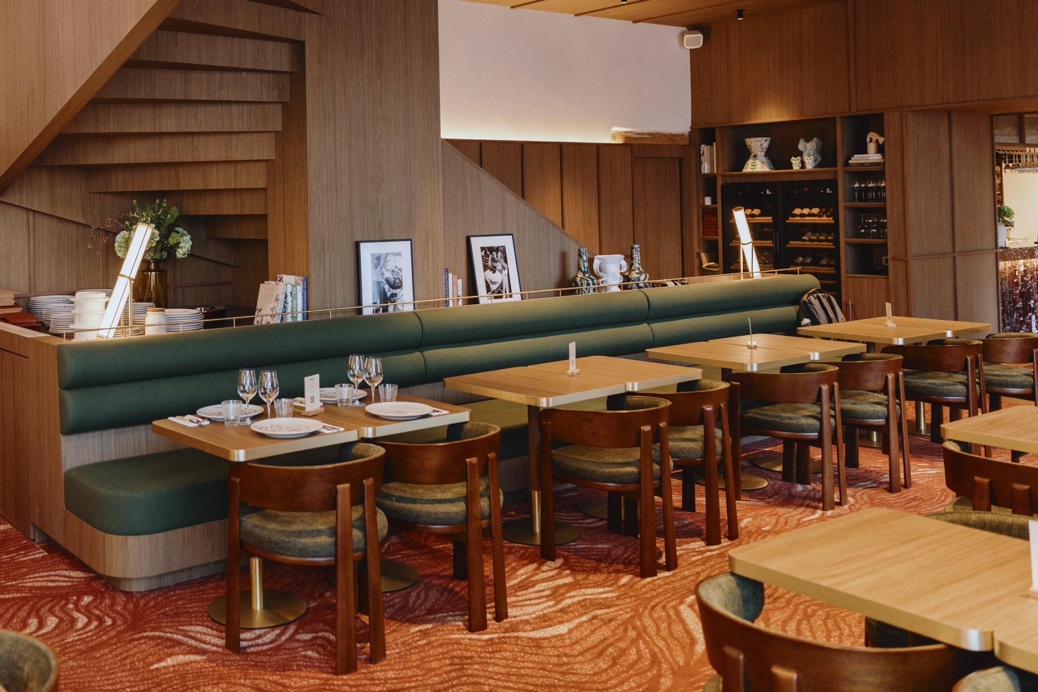 Lisse en laiton brossé et fins montants à l’arrière d’une banquette verte du restaurant GRAPPA.