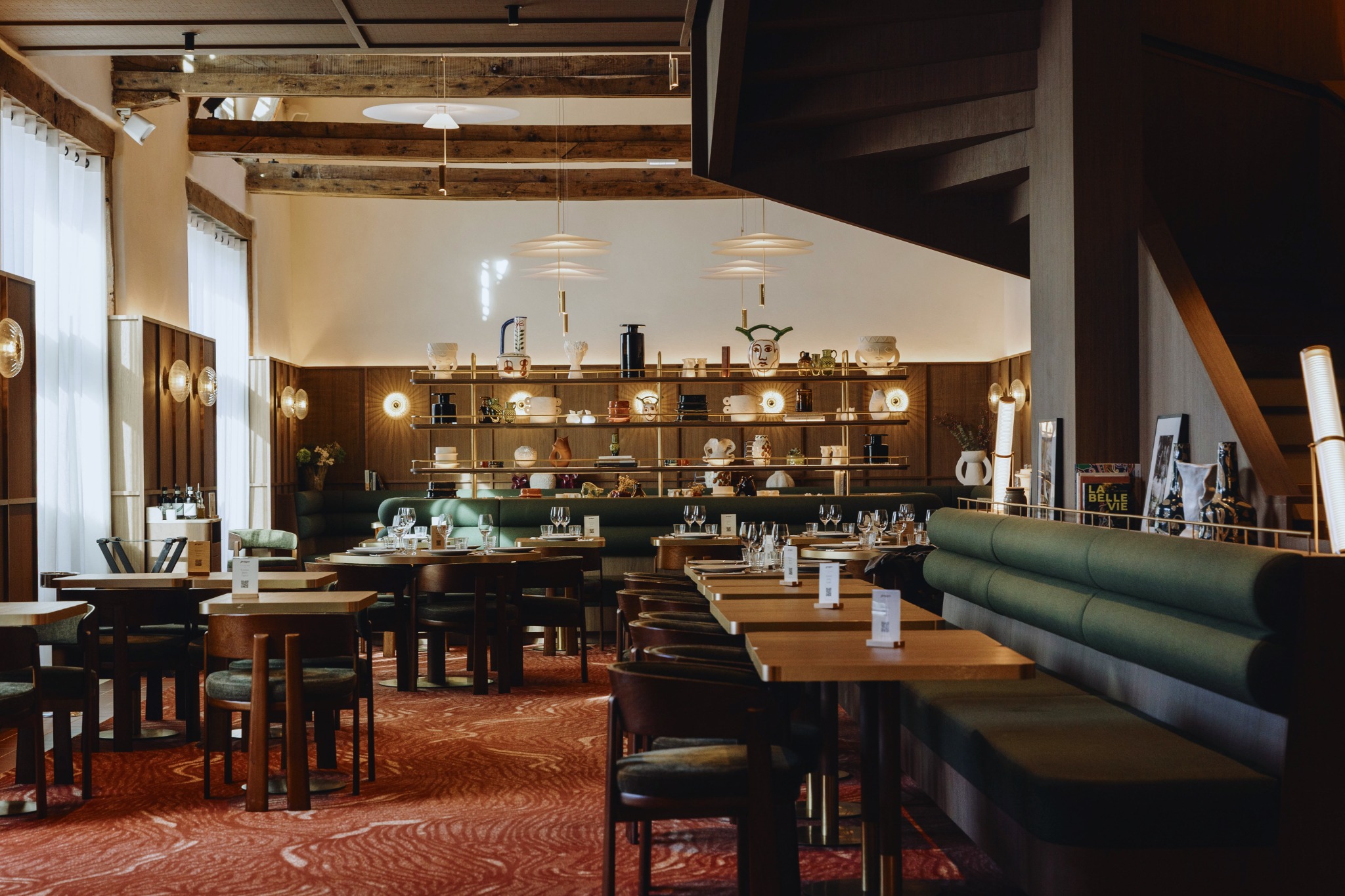 Vue d’ensemble du restaurant GRAPPA : banquettes et étagère centrale soulignées par les galeries en laiton BARRELS.