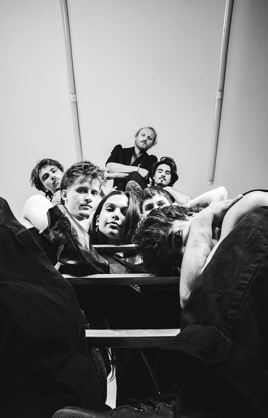 Kuga Studio team posing on a ladder.