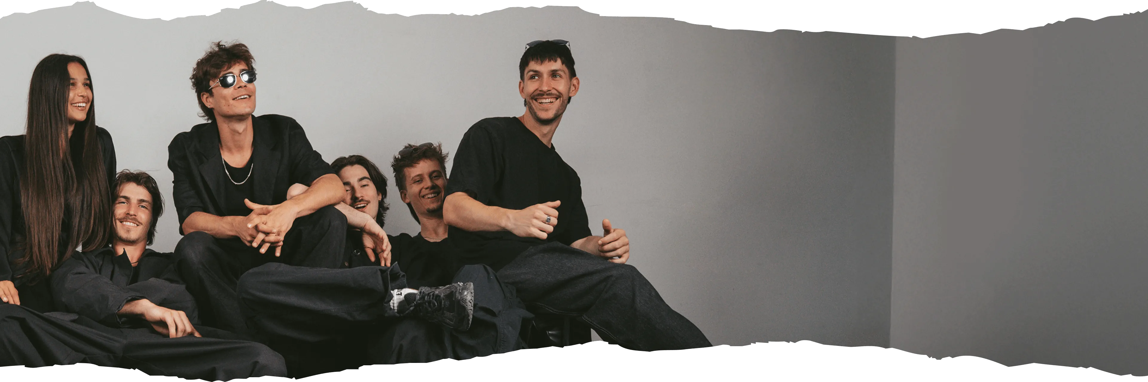 Kuga Studio members and mentors chilling on the couch and laughing.