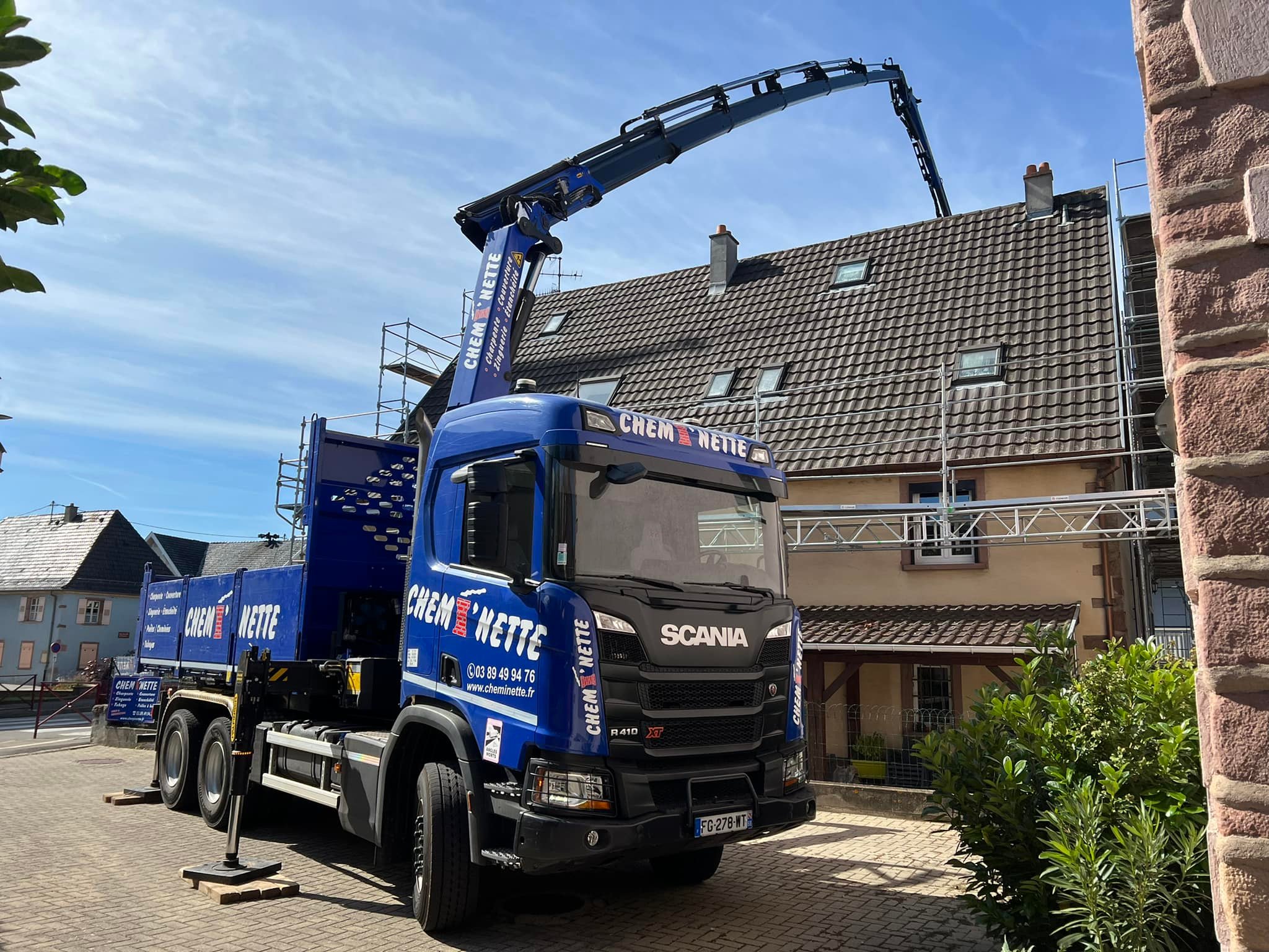 vue du camion chemi'nette avec bras qui passe par dessus une maison